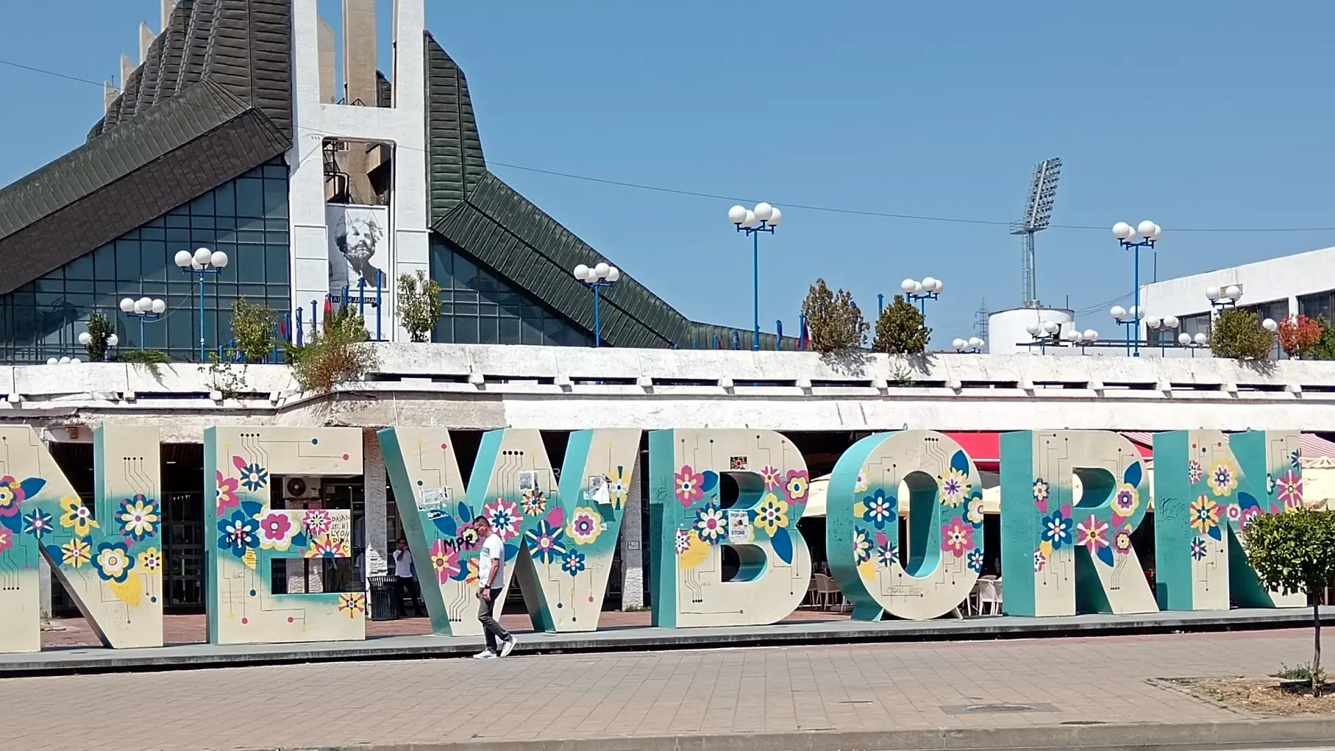 The NEWBORN monument in Prishtina painted with flowers, in front of the Palace of Youth and Sports, photographed in August 2025